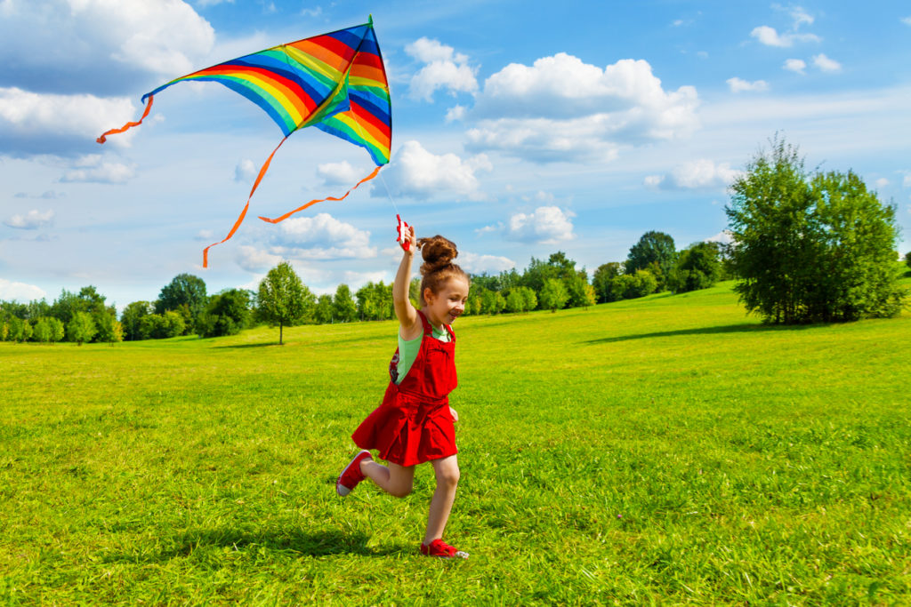 Young girl flying kite as an after-school activity