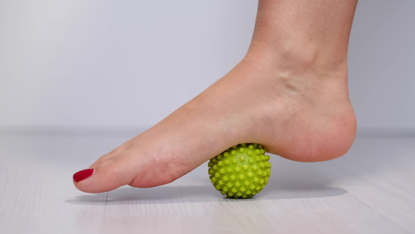 person uses roller ball on foot plantar fasciitis