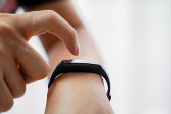 Person touches wearable device before workout.