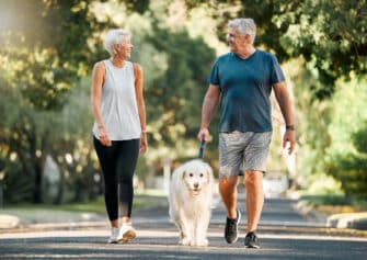 A couple walks their dog to increase their daily steps